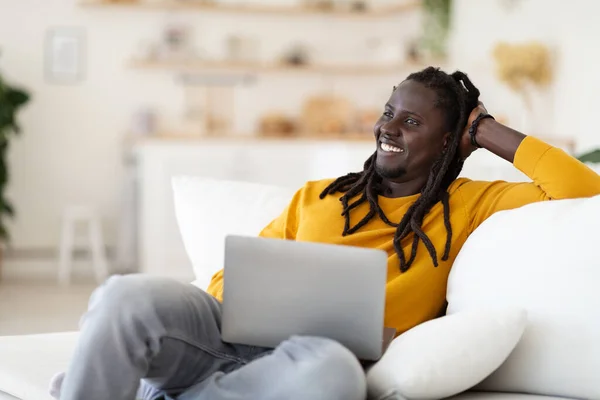 Retrato Joven Negro Sonriente Con Una Computadora Portátil Que Relaja —  Fotos de Stock