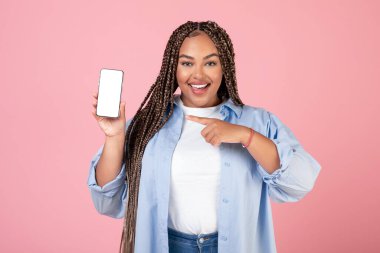 Mobil Teklif. Afrikalı Amerikalı Kadın Akıllı Telefon Stüdyodaki Pembe Arkaplan 'da Kameraya Gülümseyen Boş Ekran Pozunu Gösteriyor. Harika Uygulama Reklamı. Model