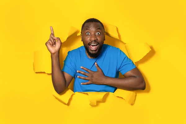 Schockierter Afroamerikaner Der Durch Ein Loch Zerrissenem Gelbem Papier Nach — Stockfoto