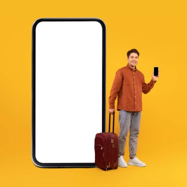 Büyük bir cep telefonunun yanında boş ekranlı turist çantalı cep telefonu pozunu ve stüdyoda sarı arka planda duran seyahat uygulamasını gösteriyor. Kare, Mockup