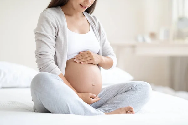 妊娠中の女性の家で寝たきりのベッドで 彼女の大きなおなかに触れ 認識できない女性彼女の妊娠を楽しんで コピースペース — ストック写真