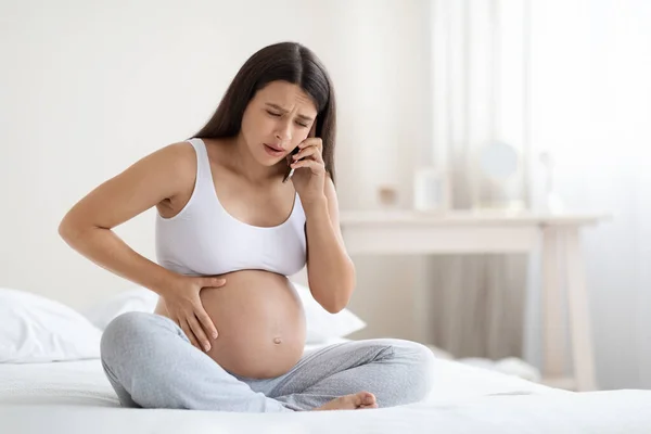 Sconvolto Giovane Donna Incinta Biancheria Casa Seduta Sul Letto Toccando — Foto Stock