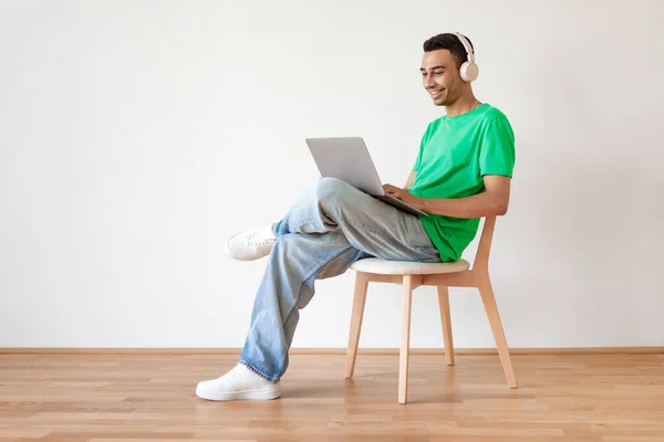 Homem Árabe Jovem Usando Trabalhando Line Laptop Vestindo Fones Ouvido — Fotografia de Stock