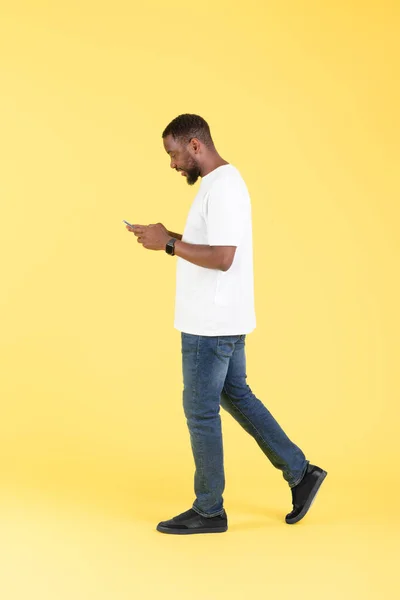 Black Guy Texting Smartphone Usando Aplicativo Móvel Andando Sobre Fundo — Fotografia de Stock