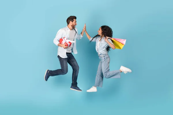 Aufgeregt Springen Millennial Internationale Paar Mit Geschenk Und Taschen Die — Stockfoto