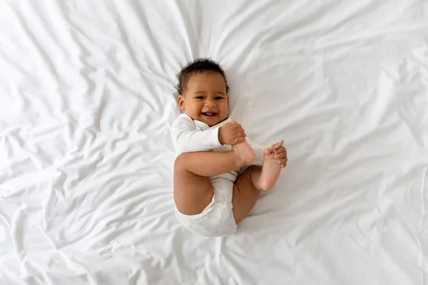 Lindo Divertido Poco Negro Bebé Teniendo Diversión Mientras Acostado Cama —  Fotos de Stock