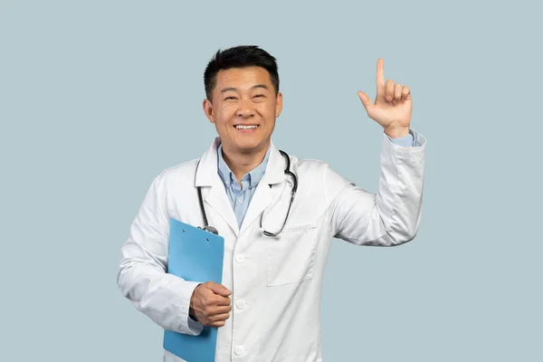 Steteskoplu Beyaz Önlüklü Neşeli Orta Yaşlı Çinli Doktor Mavi Arka — Stok fotoğraf