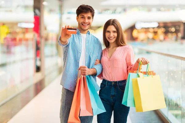 Grandes Vendas Cônjuges Alegres Mostrando Cartão Crédito Segurando Sacos Papel — Fotografia de Stock