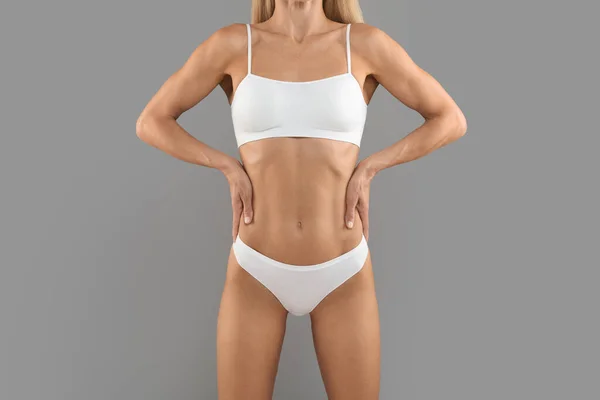 Slimming Concept. Cropped Shot Of Athletic Slim Female Body In Underwear, Unrecognizable Young Woman With Perfect Sporty Figure Standing With Hands On Waist Over Grey Background, Copy Space