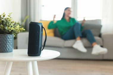 Müzik Sözcüsü, tanınmayan bir kadının internette müzik dinlemesi ve evdeki koltukta oturup dinlenmesinin keyfini çıkarması. Müzikal aletler. Seçici Odaklanma