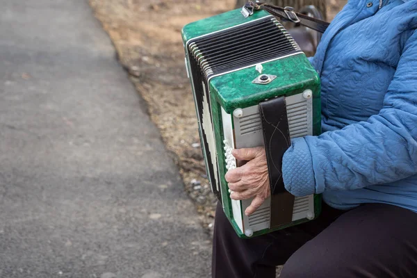 Idős nő játszik a gyönyörű régi harmonika harmonika ősszel a padon — Stock Fotó