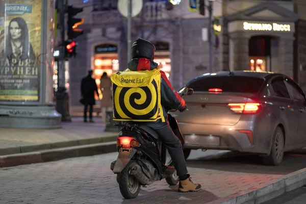 Krasnodar, Russia - January 03 2022: Yandex food delivery boy on scooter with isothermal food case — стоковое фото