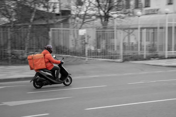 Food delivery boy on scooter with isothermal food case — стоковое фото