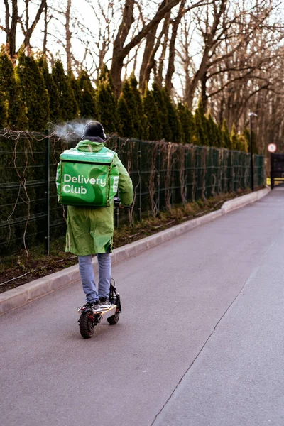 Krasnodar, Russia - January 7 2022: Food delivery boy ride on electric scooter with isothermal bag — Stock Fotó
