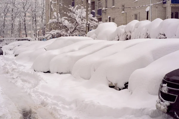 Sneeuwval in de stad. Auto bedekt met enkele centimeters sneeuw. Auto bijna helemaal begraven — Stockfoto