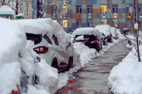 Uma queda de neve na cidade. Carro coberto de vários centímetros de neve. Carro quase totalmente enterrado — Fotografia de Stock