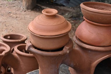 Üstü kapaklı pişirme kil tenceresi (tava) ve çift katlı kilden bir fırında pişirme kil tenceresi (pan).