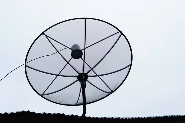 Silhouette Einer Satellitenschüssel Auf Dem Dach Eines Hauses — Stockfoto