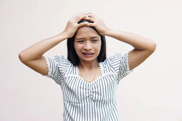 Asian women suffer from work stress. Put your hand on your head