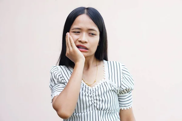 有牙痛的亚洲女人把她的手压在脸上 — 图库照片