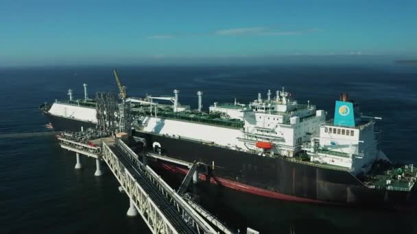 En un día de verano, enormes petroleros se abastecen de gas en el sur de la isla de Sakhalin desde una planta de GNL para su transporte a otros países. — Vídeos de Stock