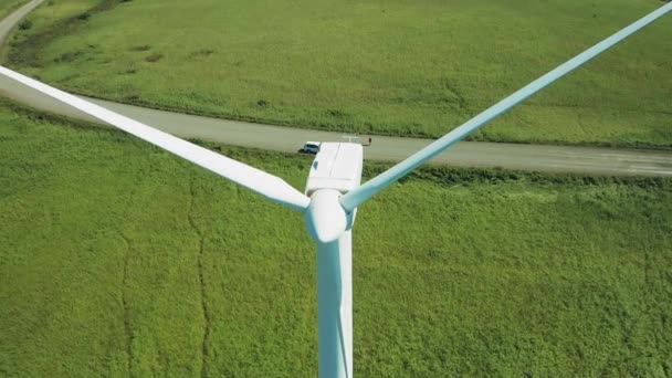 Grandes turbinas eólicas con cuchillas en campo vista aérea naranja brillante puesta del sol cielo azul parque eólico giro drone cámara lenta. Molinos de viento de siluetas, gran destello de lente de verano de disco solar naranja. Energía alternativa — Vídeo de stock