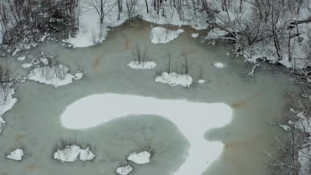 En una mañana soleada temprana vista aérea desde un dron en un lago de invierno nevado, un río cubierto con una alfombra de nieve fría. — Vídeo de stock