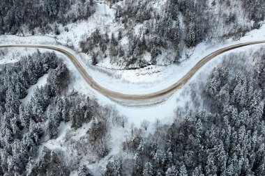 Otoyol kışın geçitten geçer, kışın karlı ormanın en üst manzarası. Karla kaplı yollar ormandan geçer dağlardan geçer geçitten geçer Aralık ayında.