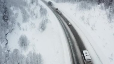 Karlı yol, aralık ayında dağlardan geçerek ormanın içinden geçer. Araba kışın karlı ormanda, kışın tepedeki yolda yol alır..