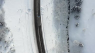 Karlı yol, aralık ayında dağlardan geçerek ormanın içinden geçer. Araba kışın karlı ormanda, kışın tepedeki yolda yol alır..