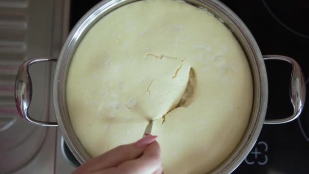 Kocken kokar kesosten, slår, tillsätter russin och nötter och rör om i ostmassan. Knåda ostdegen i en vit skål med en handmixer. Processen att göra ostmassa bagels eller croissanter. — Stockvideo