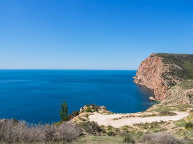 Kırım 'daki kayaların ve denizin manzarası. Kar maskesi mevsiminde dağ ve deniz manzarası.