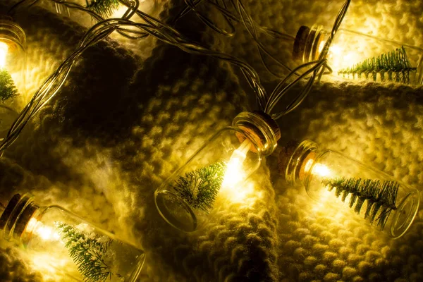 一只漂亮的手工制作的圣诞树花环躺在一件白色针织毛衣上 花环由玻璃瓶制成 内有圣诞树和人造雪 圣诞周末的舒适和惬意 — 图库照片