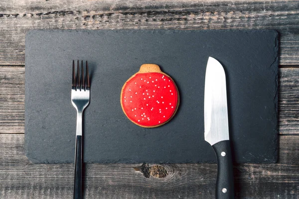 Ingwerkekse Form Eines Roten Kugelweihnachtsbaumschmucks Liegen Auf Einer Schwarzen Schiefertafel — Stockfoto