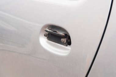 Gri bir otomobilin kapı kolu kırılmış. Araba hackleme, tamir ve sigorta kavramı..