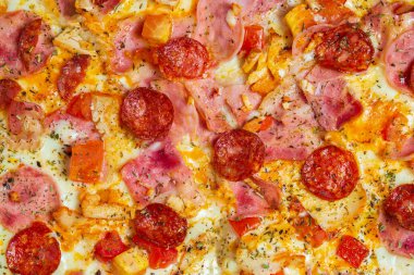 Domatesli, salamlı ve sucuklu pizzanın dokusunu yakından çek. İtalyan yemeği, sağlıksız yemek..