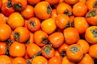 Olgun tatlı hurmanın turuncu arkaplanı tam kare yakın plan.