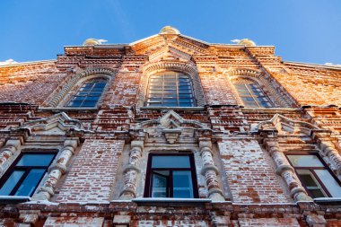 Eski bir katedralin tarihi binasının ön cephesi ya da yakın planda bir kırmızı tuğla tapınak. Alt manzara. Plastik pencereler tarihi binanın manzarasını bozar.