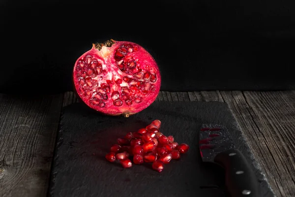 Half Red Pomegranate Fruit Pile Seeds Black Slate Cutting Board — Stock Photo, Image