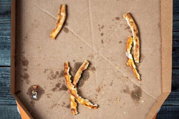Kirli ve boş bir pizza kutusu. Yemek artıkları ve yemek artıkları pizza kabuklarını ziyan ediyor..