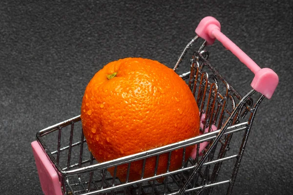 Een Gewassen Sinaasappel Met Waterdruppels Een Winkelwagen Een Zwarte Achtergrond — Stockfoto