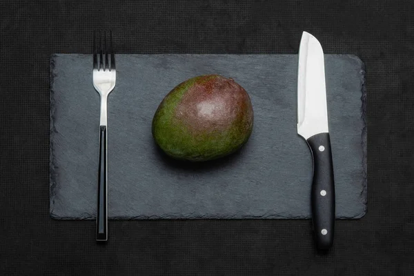 Grüne Mango Mit Serviergabel Und Messer Auf Einer Schiefertafel Das — Stockfoto