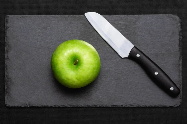 Una Manzana Verde Junto Cuchillo Servir Una Pizarra Negra Concepto — Foto de Stock