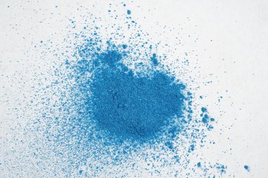 Beyaz arka planda mavi kuru boya veya toz yığını.