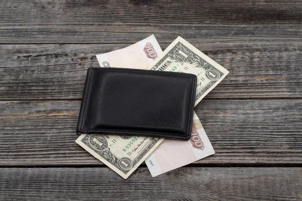 Twee Geld Biljetten Een Zwarte Portemonnee Een Houten Tafel Achtergrond — Stockfoto