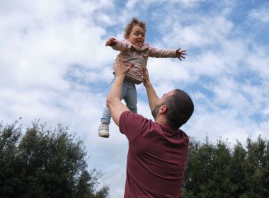 Baba ve kızı açık havada top oynuyorlar. Baba ve kız gülüyor ve mutlu, ebeveynlik, babalar günü.