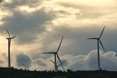 Rüzgar türbinleri gün batımında dağlarda bir rüzgar çiftliğinde. yeşil ekolojik enerji.
