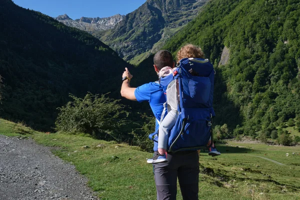 山の中で赤ちゃんのキャリアバックパックハイキングを持つ父 父と娘 家族の冒険 健康的な生活 ロイヤリティフリーのストック画像