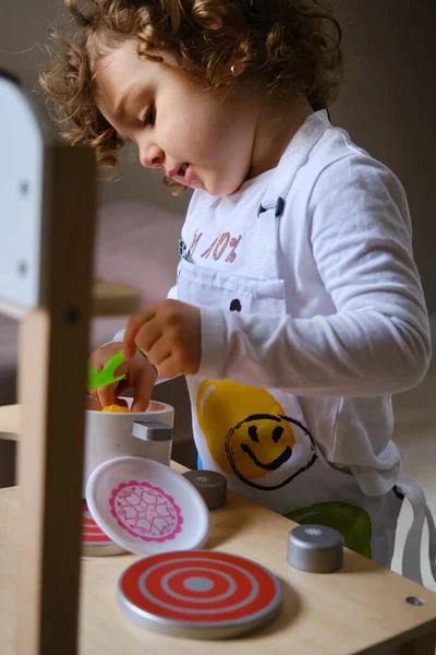 女の子遊びます料理ととともにおもちゃキッチンにホーム ロイヤリティフリーのストック写真