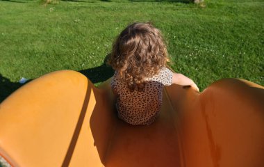 happy girl enjoying going down the slide in the park - playground